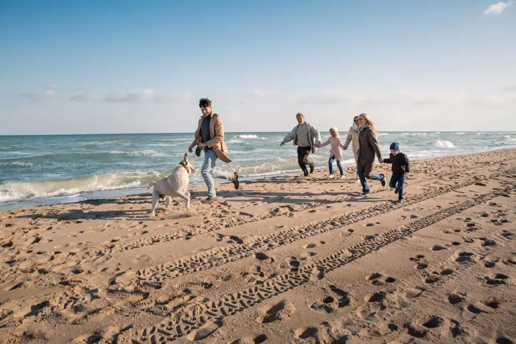 Dog-Running-with-Family-on-Beach